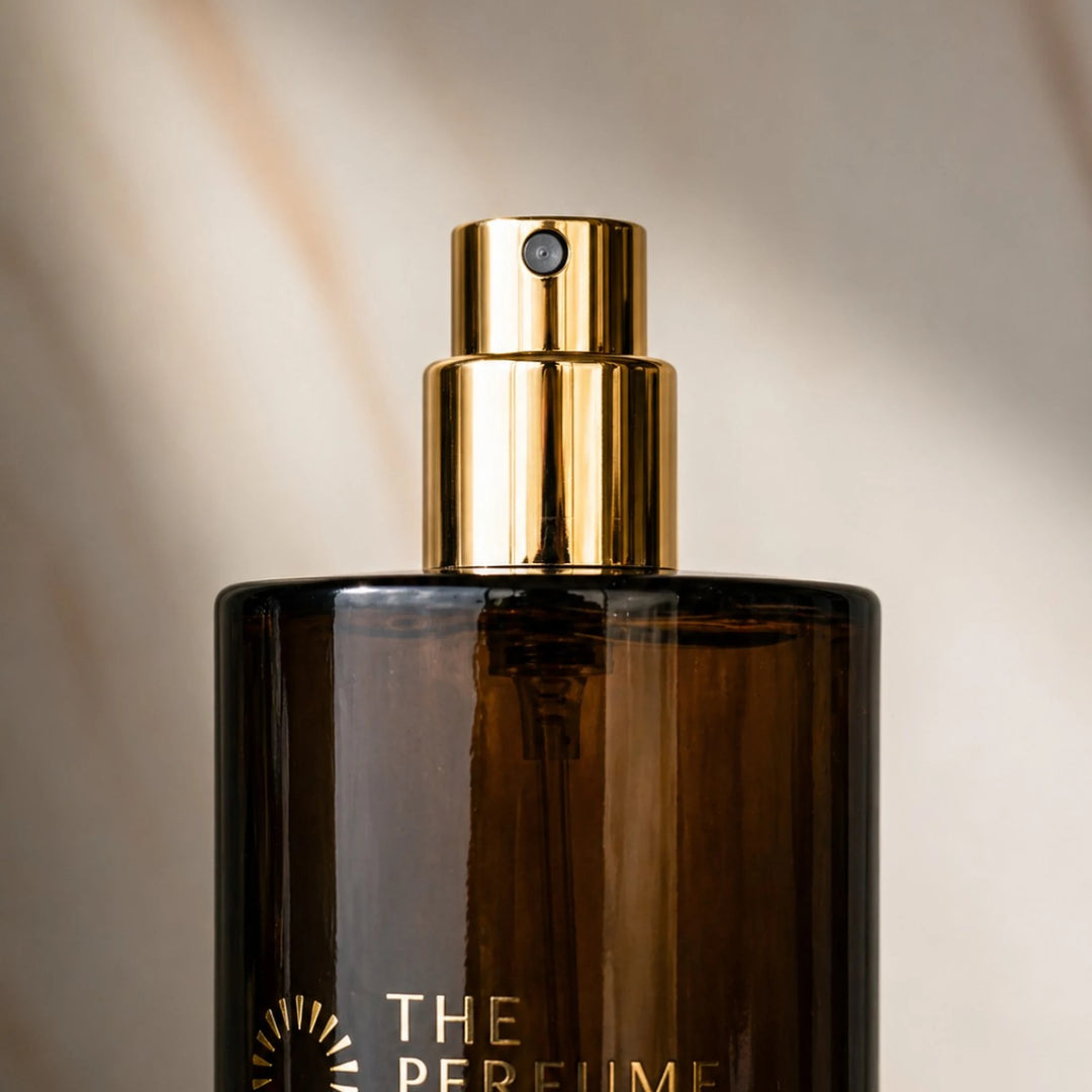 Close-up of gold spray nozzle on dark amber glass bottle, City Lights 50ml parfum spray by The Perfume Treasury, luxury atomiser detail on neutral background.
