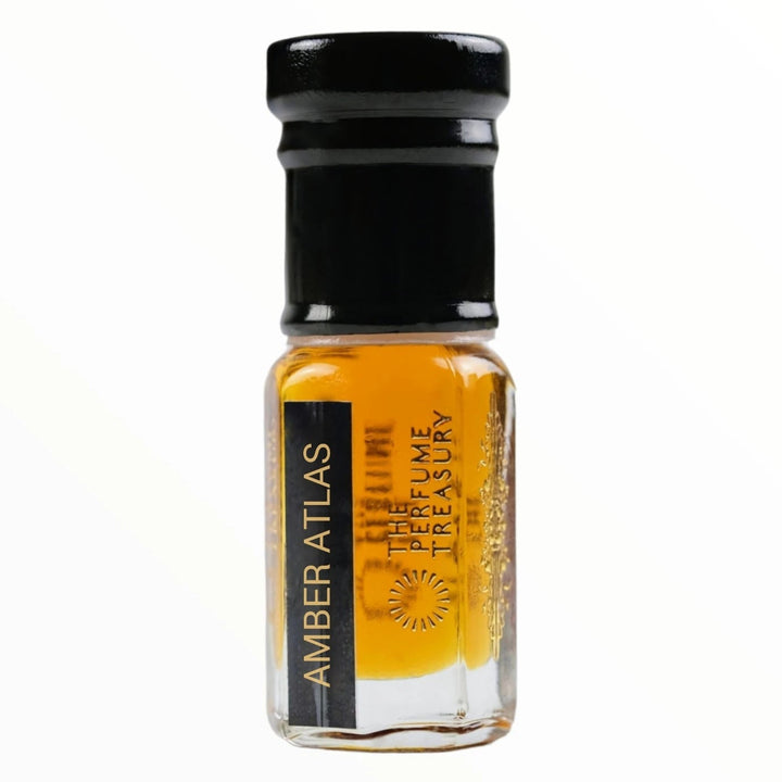 Close-up macro of Amber Atlas perfume oil bottle by The Perfume Treasury, showing warm amber oil texture and reflective clear glass finish, concentrated perfume oil in clear glass bottle with black cap.