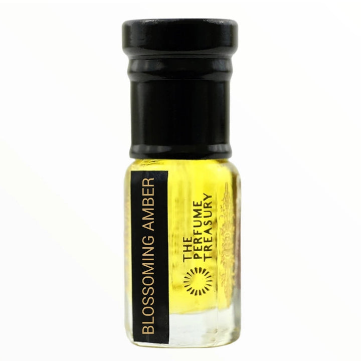 Premium studio shot of Blossoming Amber perfume oil in a clear designer bottle with rich yellow fragrance oil, black cap and gold typography against a minimalist white backdrop.