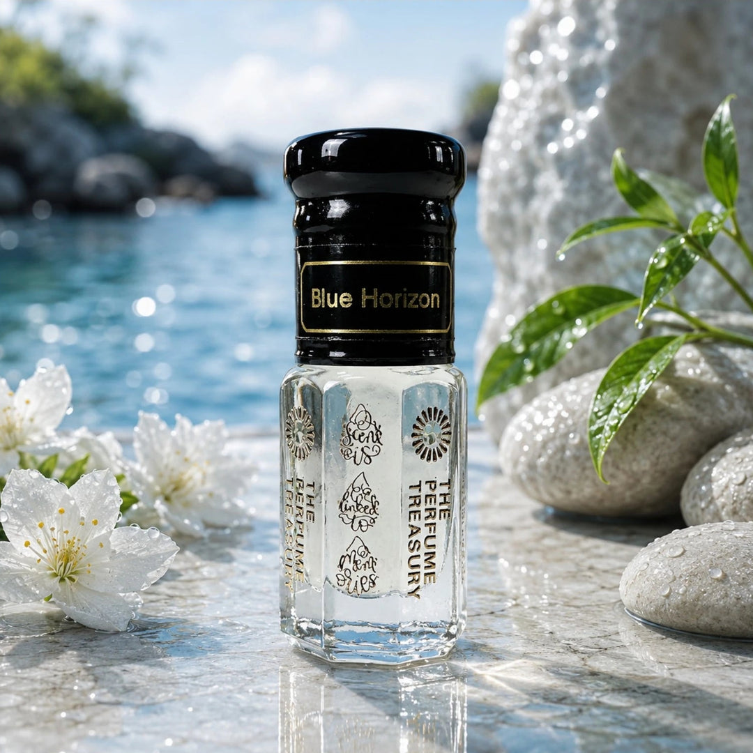Refreshing spa-inspired lifestyle image of Blue Horizon perfume oil bottle surrounded by white flowers, smooth stones and lush green leaves beside shimmering blue water, creating a calm and elegant luxury fragrance setting.