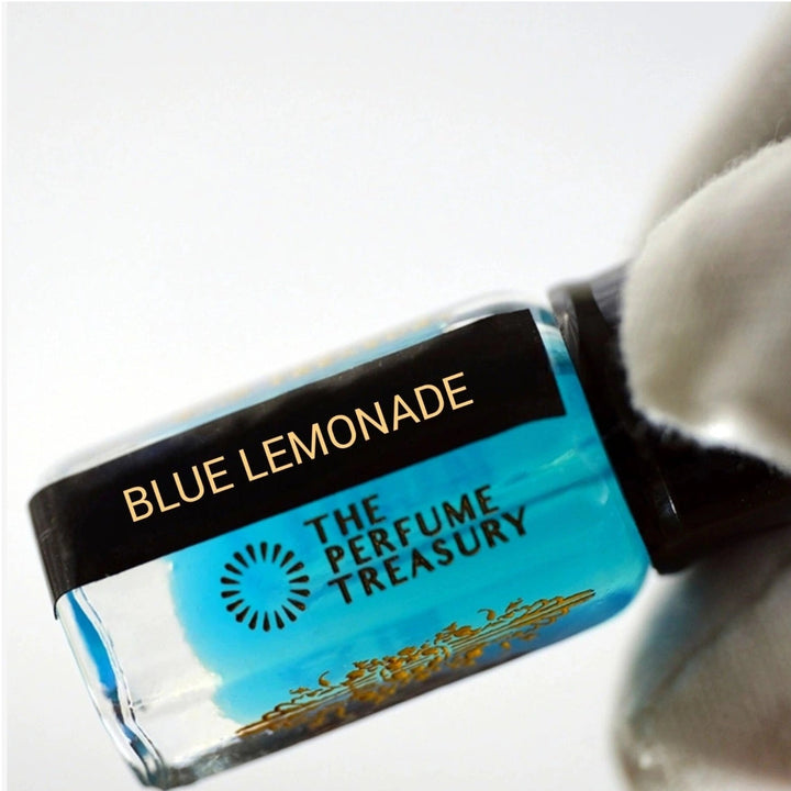 Close-up of Blue Lemonade musk perfume oil bottle held in white glove, showcasing bright aquatic blue fragrance oil by The Perfume Treasury.