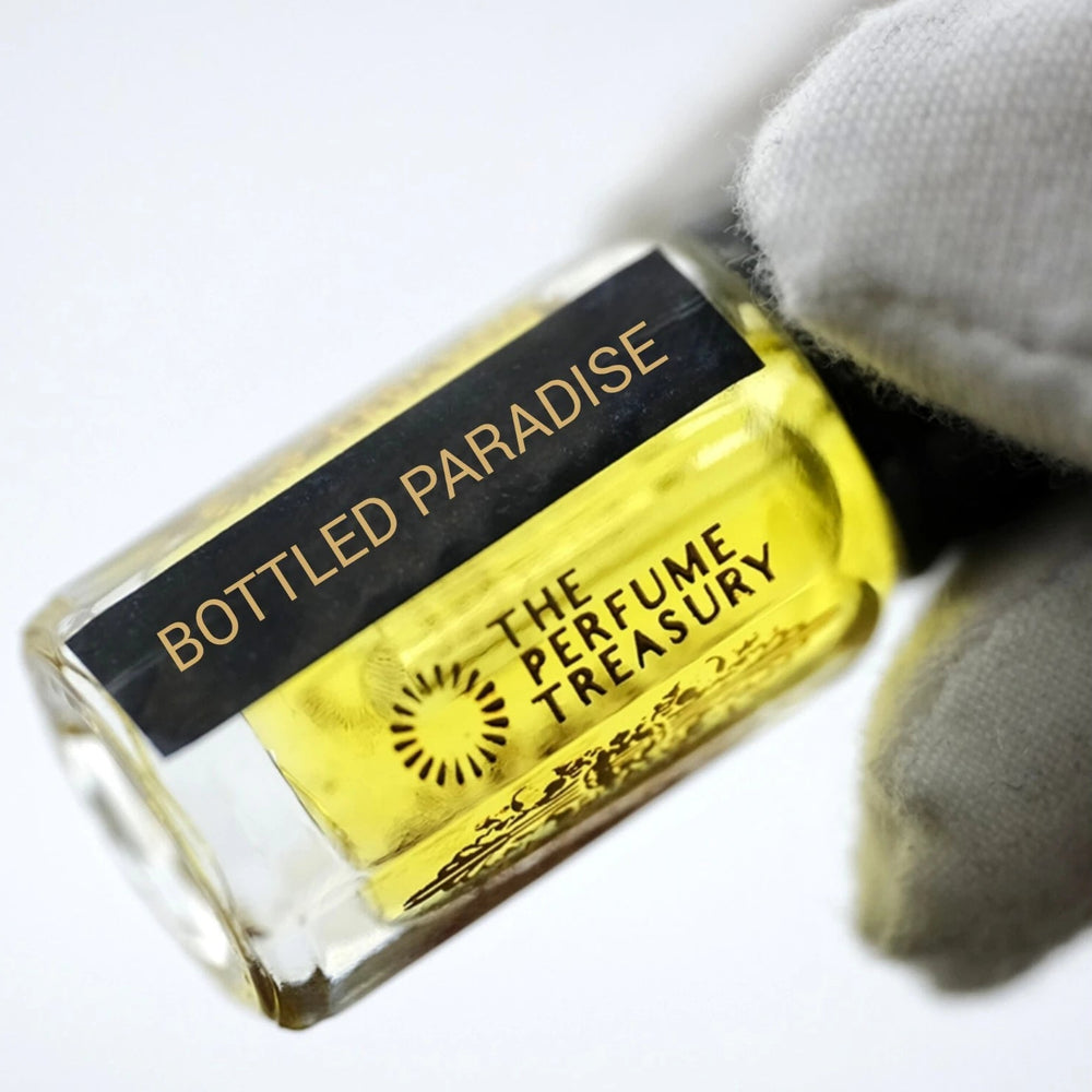 Close-up of Bottled Paradise attar perfume oil bottle held with white glove, showcasing premium tropical fragrance oil.