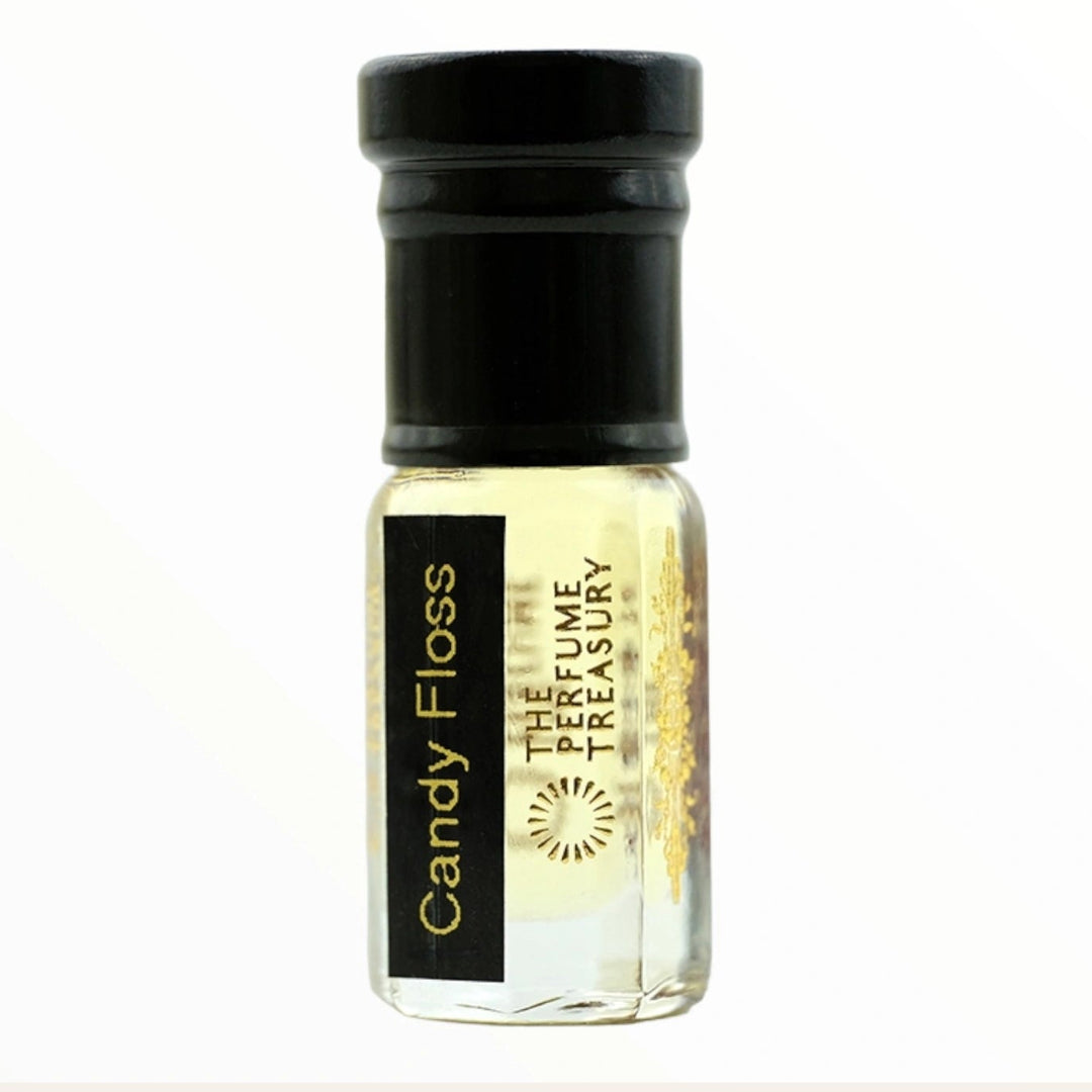 Small clear glass perfume oil bottle with black cap, Candy Floss 3ml attar perfume oil by The Perfume Treasury, soft pale golden sweet fragrance oil on white background.