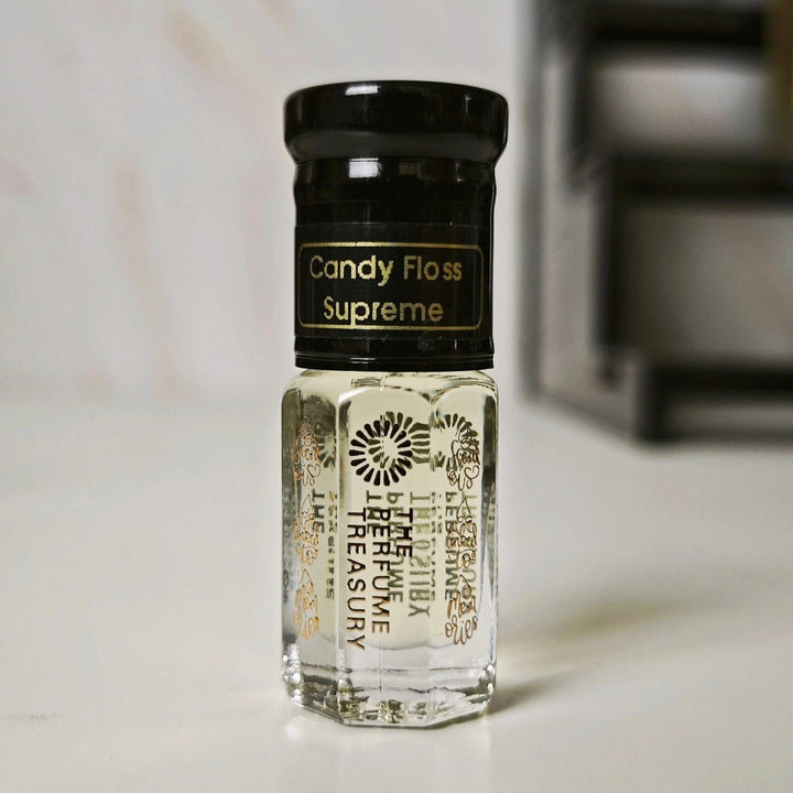 Candy Floss Supreme 3ml attar perfume oil by The Perfume Treasury on soft indoor background, clear glass bottle with black cap and light sweet fragrance oil.