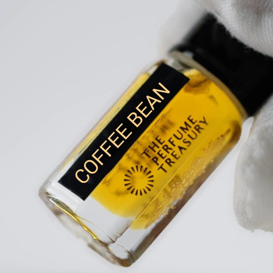 Close-up of Coffee Bean luxury perfume oil 3ml bottle held in hand showcasing rich amber fragrance oil and premium artisan bottle design by The Perfume Treasury.