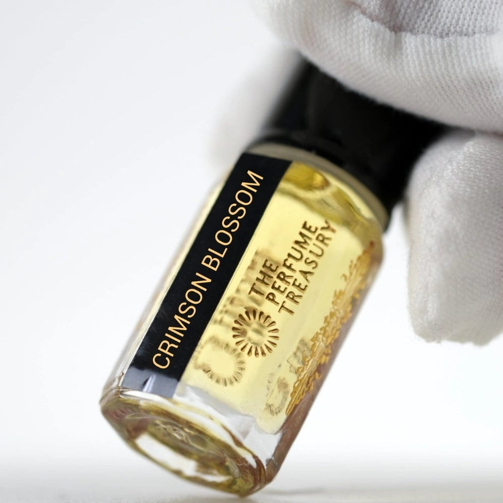 Close-up of Crimson Blossom perfume oil by The Perfume Treasury held in hand, showcasing the premium glass bottle, concentrated fragrance oil and luxury label details.