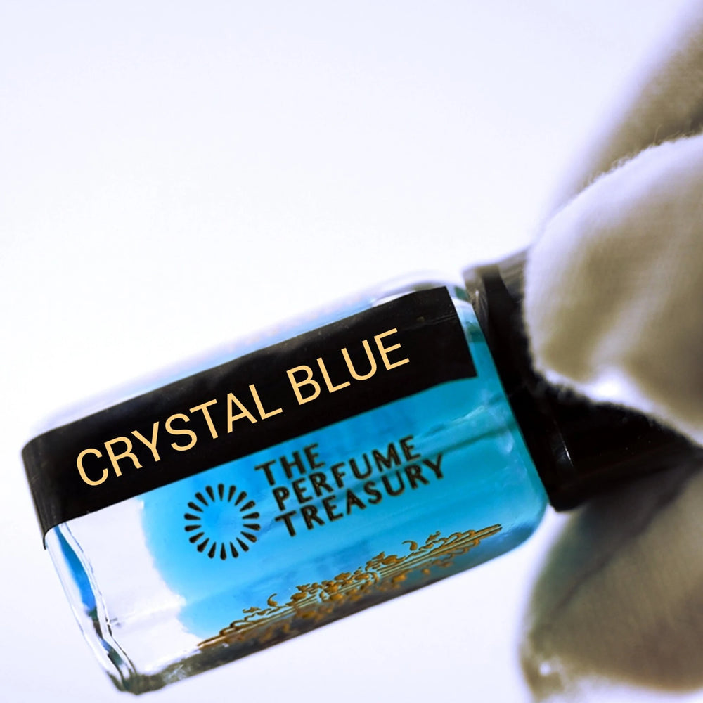 Close-up macro of Crystal Blue perfume oil showing vibrant blue liquid and luxury bottle detailing.