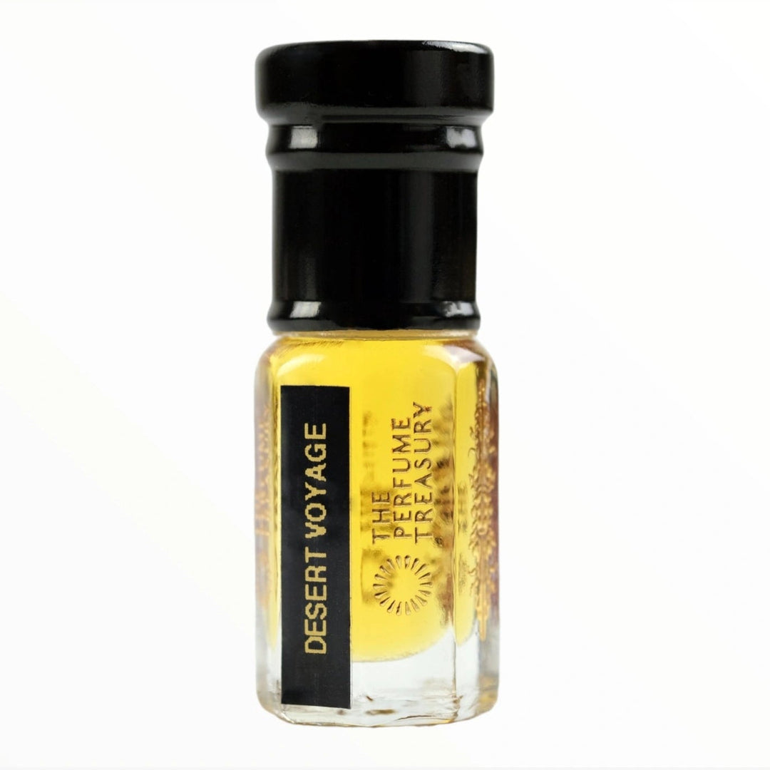 Small clear glass perfume oil bottle with black cap, Desert Voyage 3ml attar perfume oil by The Perfume Treasury, warm rich golden fragrance oil on white background.