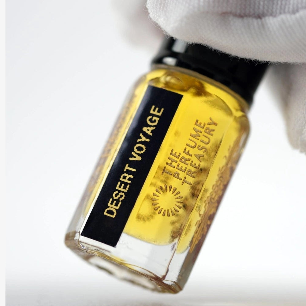 Macro close-up of Desert Voyage perfume oil highlighting rich golden texture and glass detail.