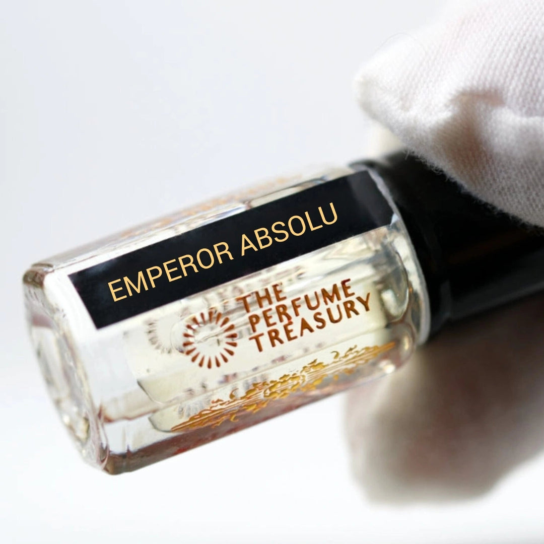 Close-up angled image of Emperor Absolu attar perfume oil by The Perfume Treasury held in a white glove, highlighting the premium bottle design and luxury alcohol-free fragrance oil presentation.