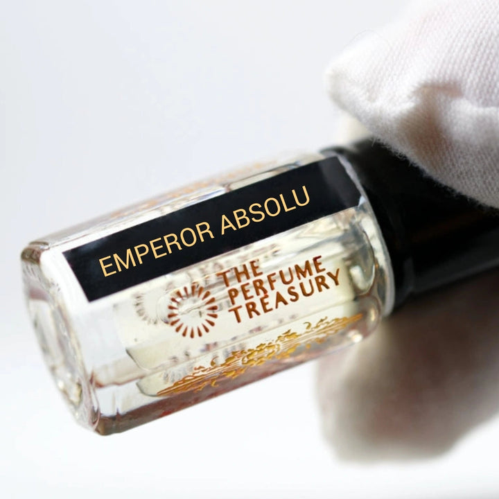 Close-up angled image of Emperor Absolu attar perfume oil by The Perfume Treasury held in a white glove, highlighting the premium bottle design and luxury alcohol-free fragrance oil presentation.