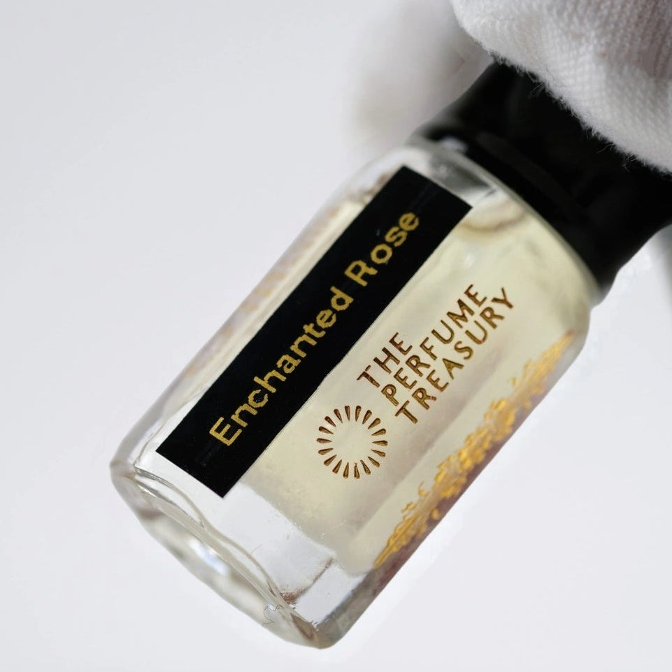 Close-up of Enchanted Rose Musk Tahara perfume oil bottle held in white glove, showcasing creamy floral musk oil by The Perfume Treasury.
