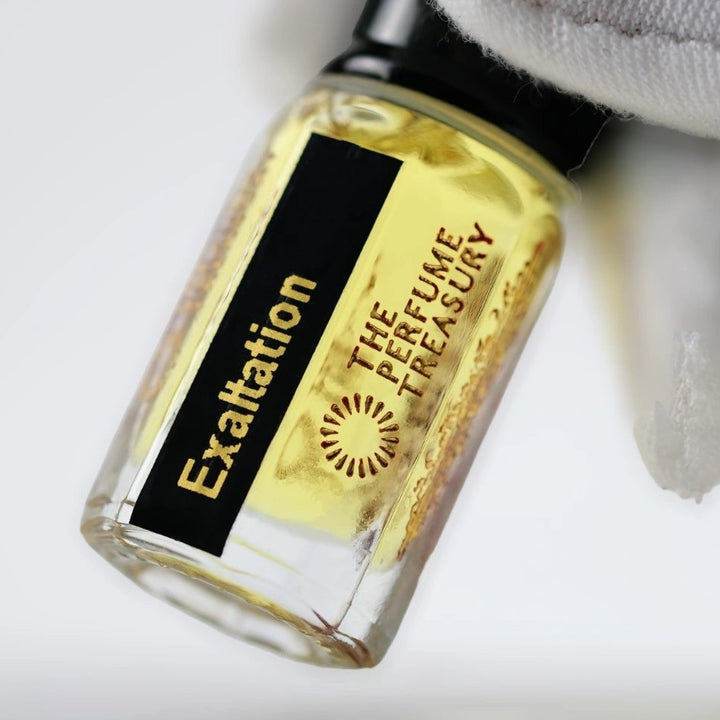 Close-up angled image of Exaltation attar perfume oil by The Perfume Treasury held in a white glove, highlighting the luxury bottle design and premium alcohol-free perfume oil presentation.