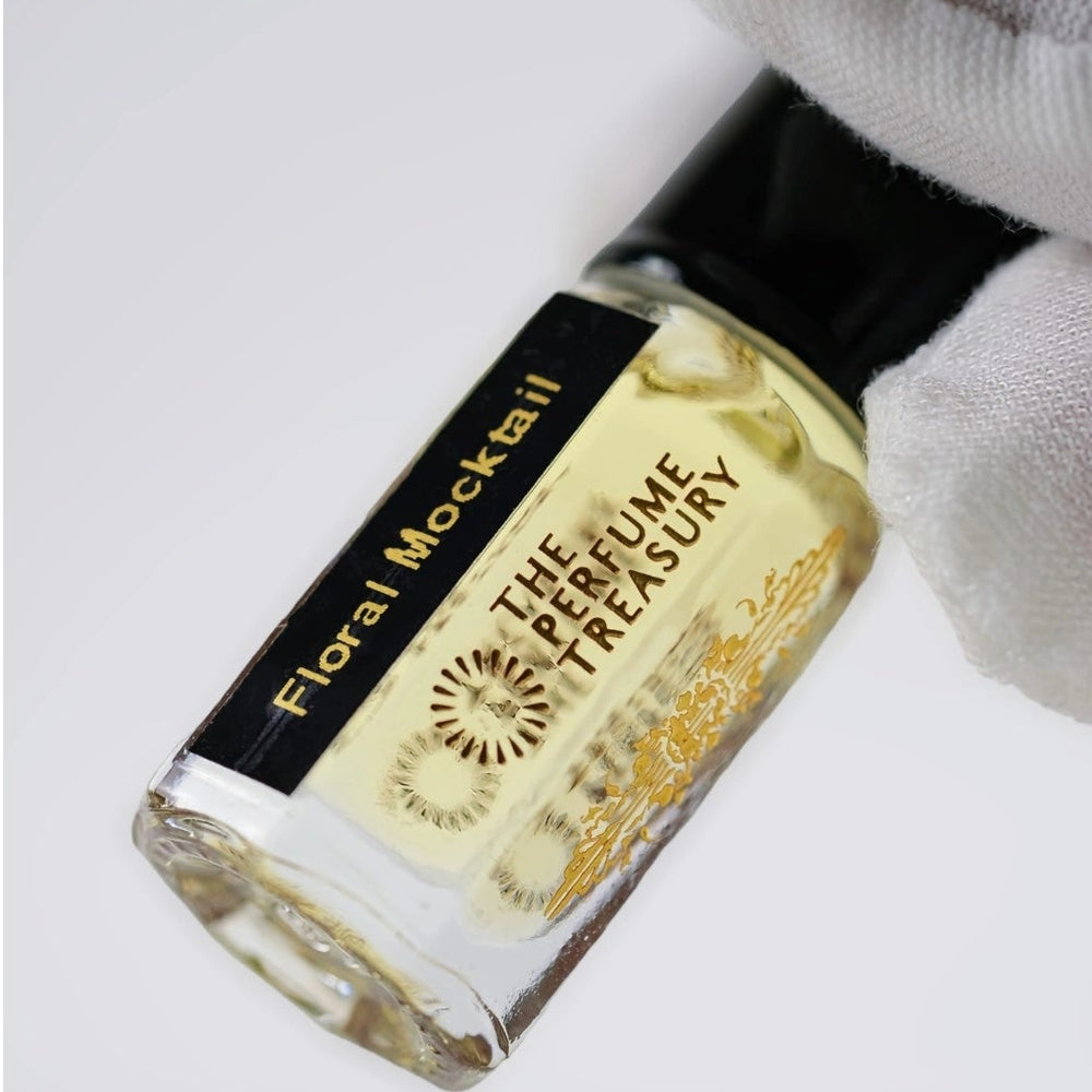 Close-up of Floral Mocktail attar perfume oil by The Perfume Treasury, showcasing the pale golden fragrance oil, black label and luxury glass bottle.