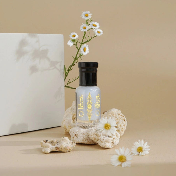 Perfume oil displayed with white flowers and neutral tones, representing a fresh and clean fragrance profile.