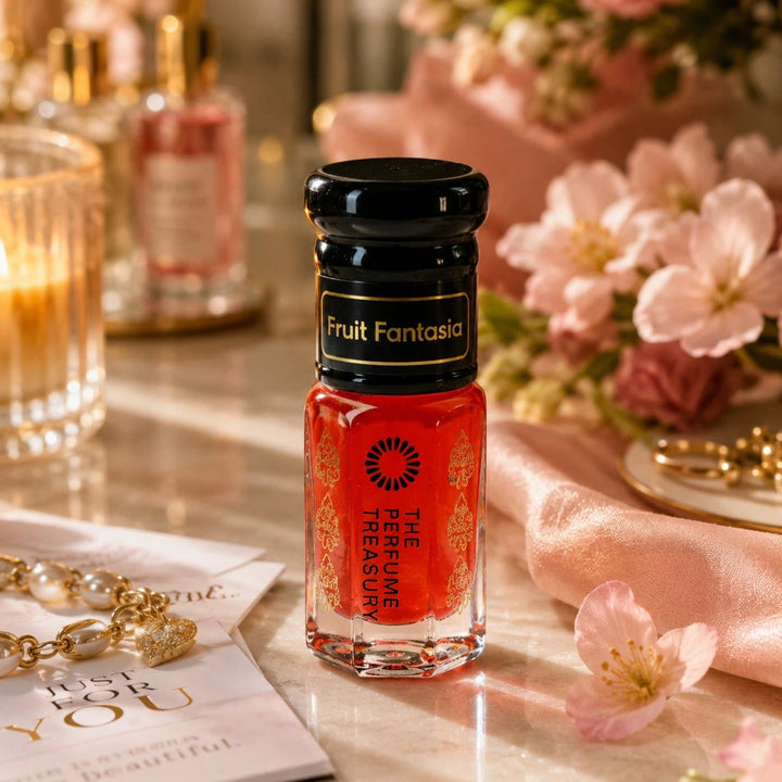 Fruit Fantasia Musk Tahara perfume oil hero lifestyle image featuring a vibrant fruity floral body musk fragrance oil surrounded by pink blossoms, satin fabric and luxury accessories, showcasing juicy citrus, peach, apricot and creamy musk notes in a long-lasting alcohol-free perfume oil by The Perfume Treasury.