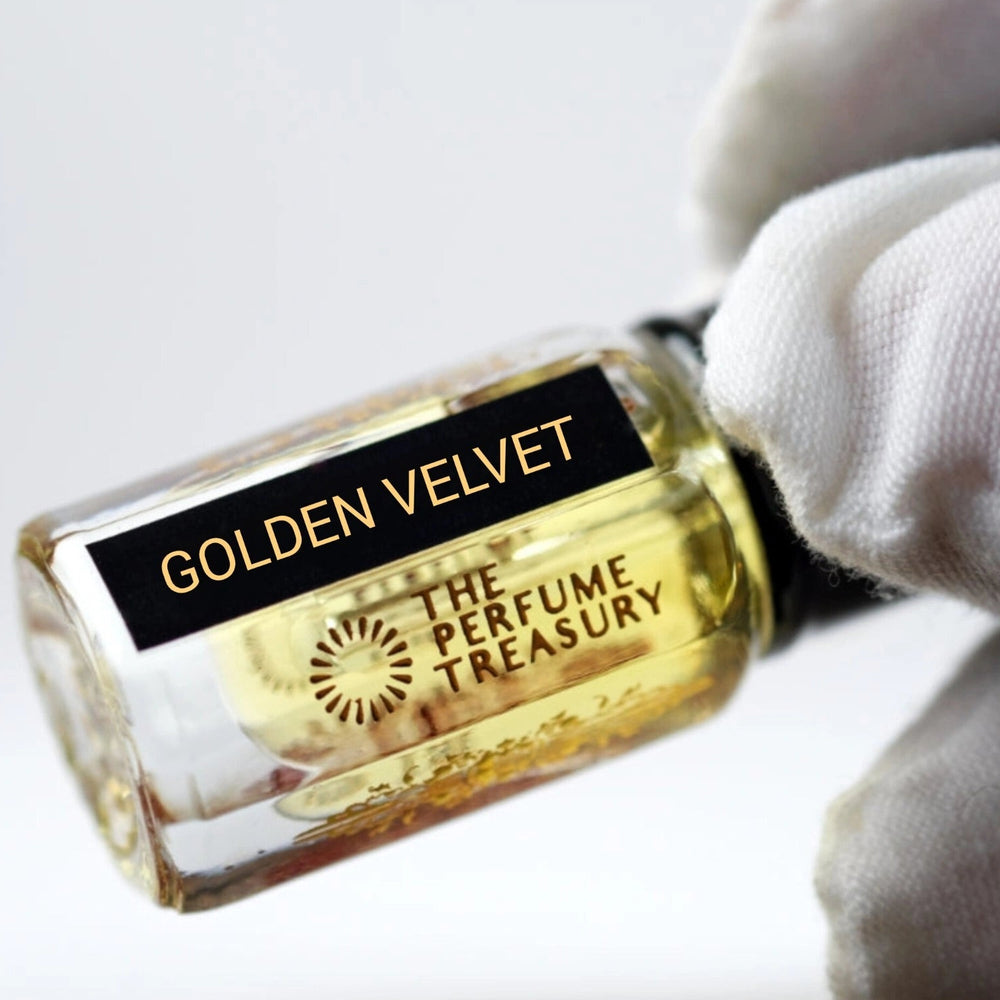 Close-up of a small Golden Velvet Attar Perfume Oil bottle by The Perfume Treasury, 3ml roll-on perfume oil with black cap and black label, photographed against a soft white background.