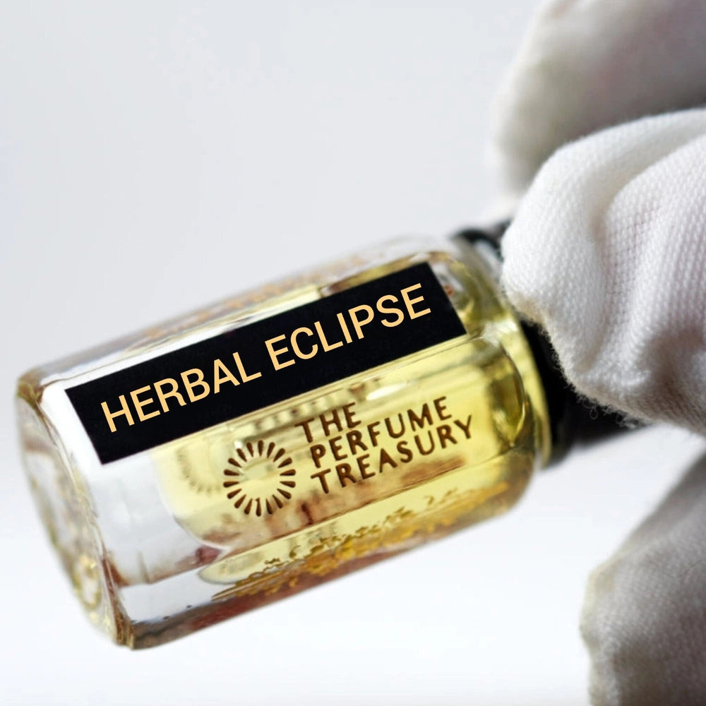 Close-up of Herbal Eclipse Attar Perfume Oil by The Perfume Treasury, 3ml perfume oil bottle with black cap and label held against a soft white background.