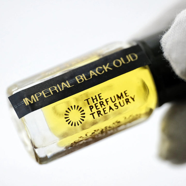 A close-up of a perfume oil bottle labeled &