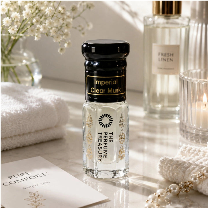 Imperial Clear Musk Tahara perfume oil hero lifestyle image featuring a clean fresh body musk fragrance oil surrounded by soft white linens, fresh florals, luxurious towels and calming spa-inspired accents, showcasing a pure skin scent with soft musk, creamy notes and fresh elegance by The Perfume Treasury.