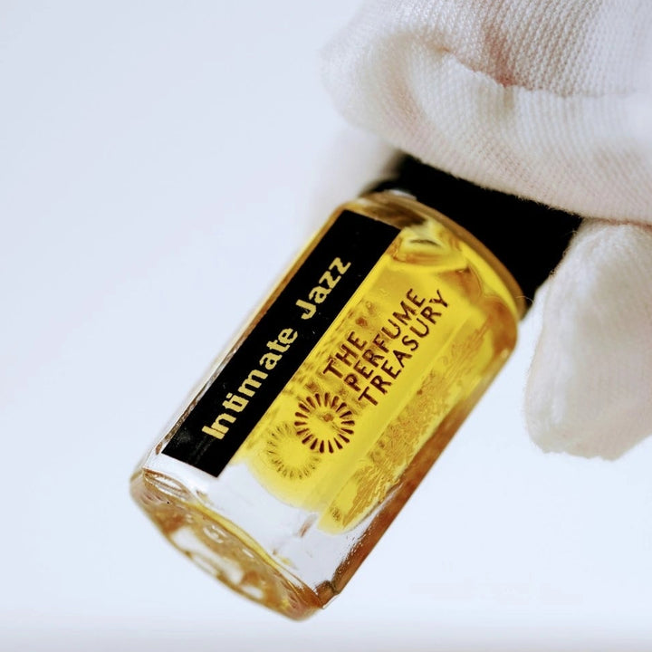Close-up of Intimate Jazz Perfume Oil by The Perfume Treasury, showing the golden fragrance oil and branded 3ml bottle.