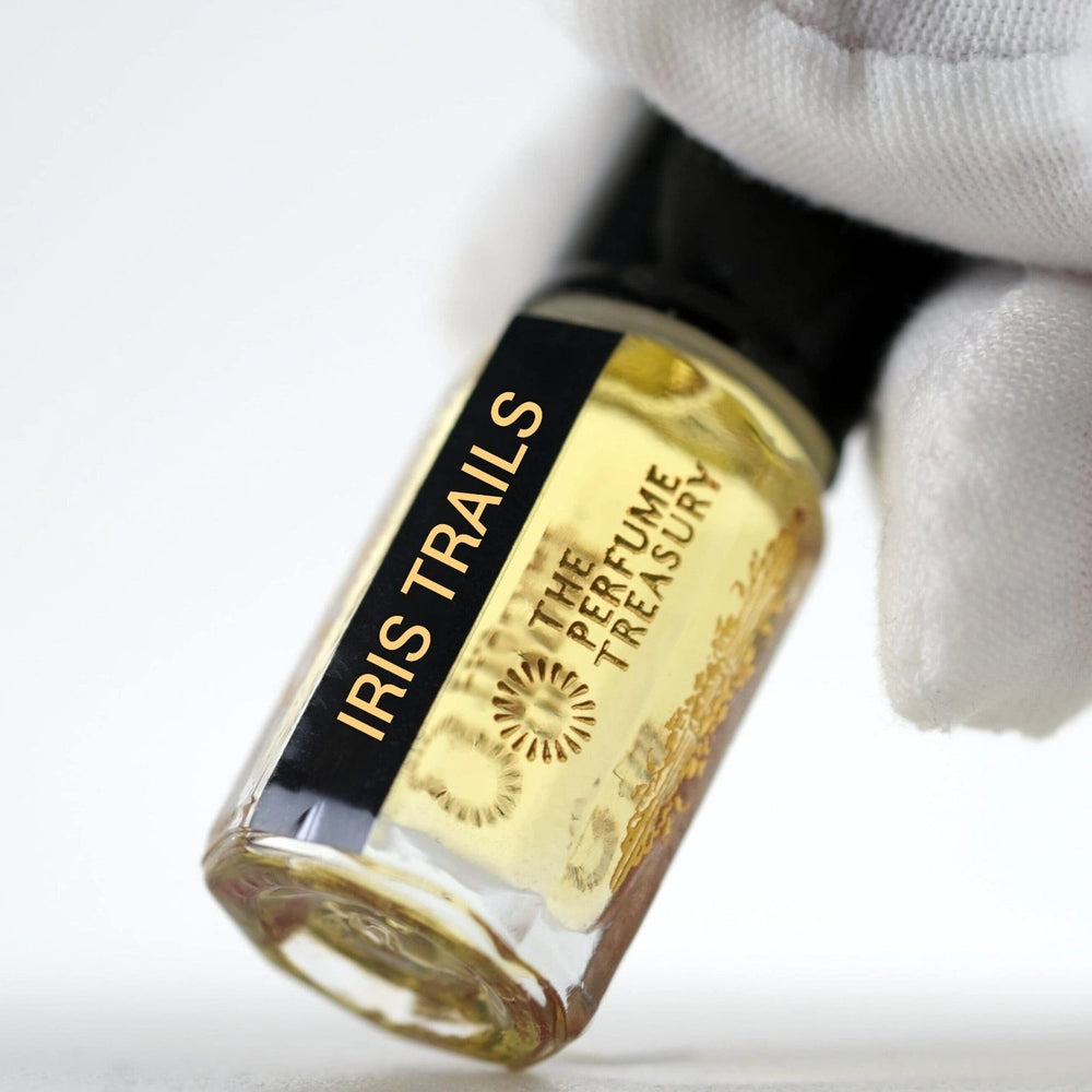 Close-up of Iris Trails Perfume Oil by The Perfume Treasury, showing the golden fragrance oil and branded glass bottle.