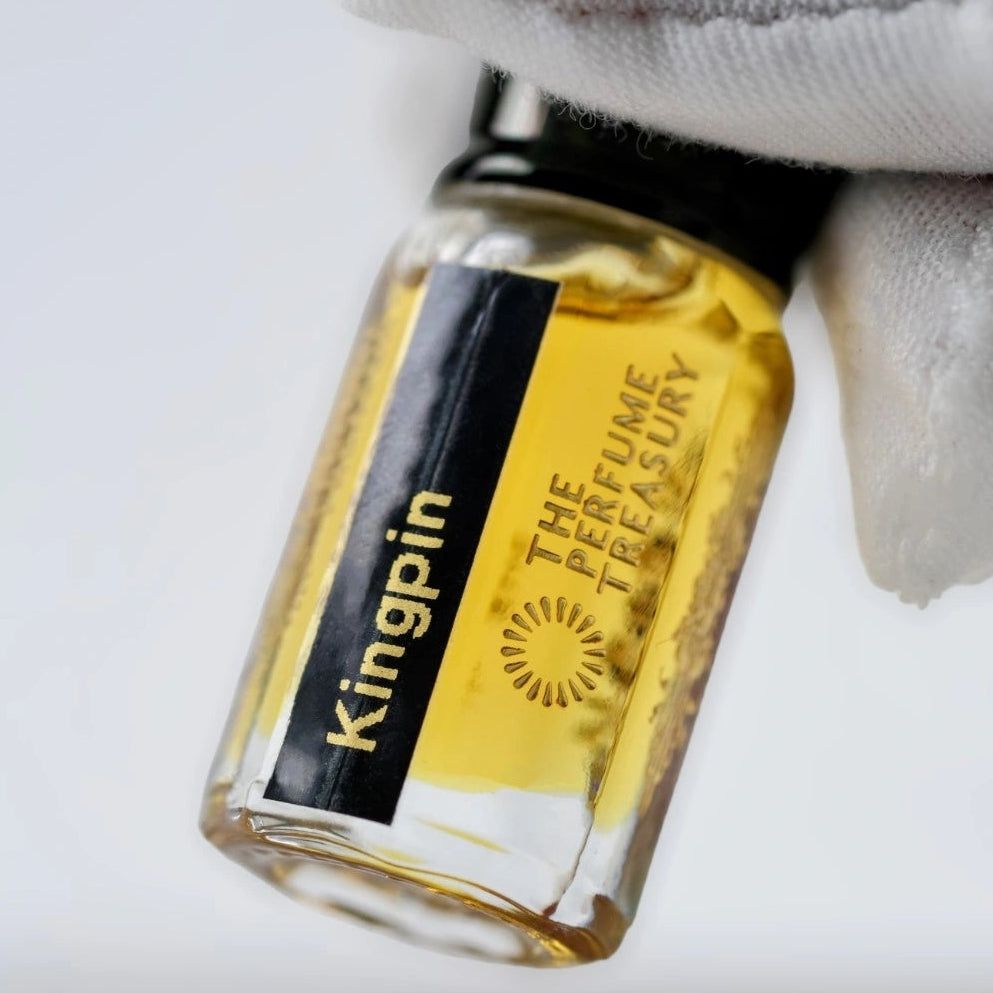 Close-up of Kingpin Perfume Oil by The Perfume Treasury showing the rich golden perfume oil and black fragrance label.