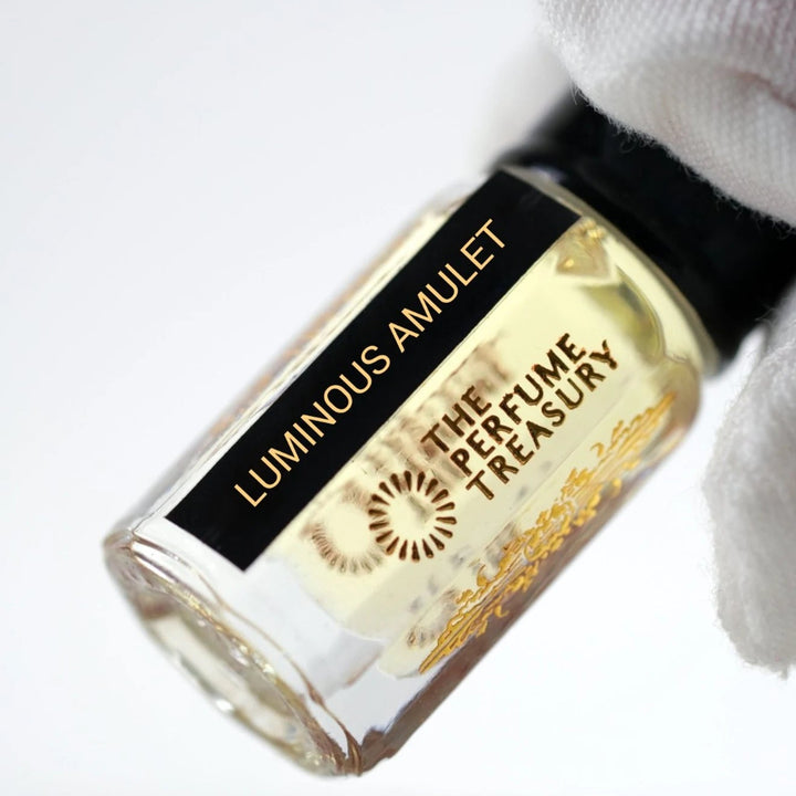Close-up of Luminous Amulet perfume oil bottle by The Perfume Treasury showing the black and gold label.