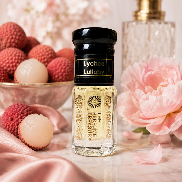 Lychee Lullaby perfume oil by The Perfume Treasury displayed with fresh lychees, pink flowers and soft satin in a luxurious feminine setting.