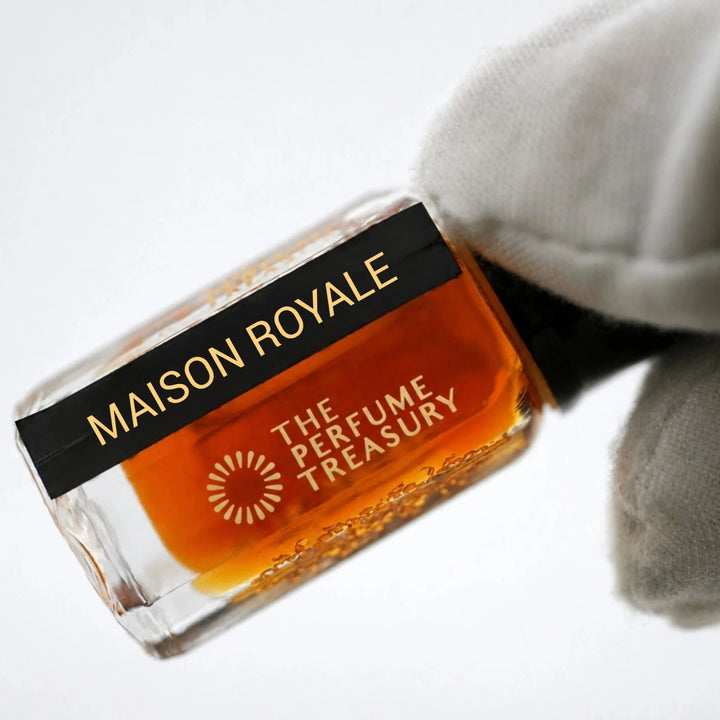 Close-up of Maison Royale perfume oil bottle by The Perfume Treasury showing the black and gold label and rich amber fragrance oil.