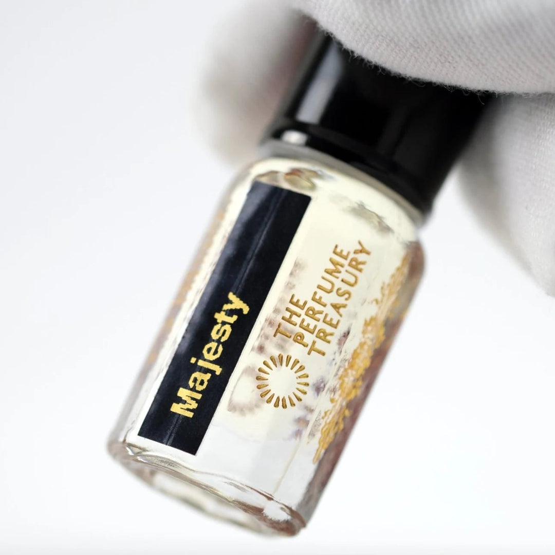 Close-up of Majesty perfume oil by The Perfume Treasury showing the black and gold label and pale golden perfume oil.