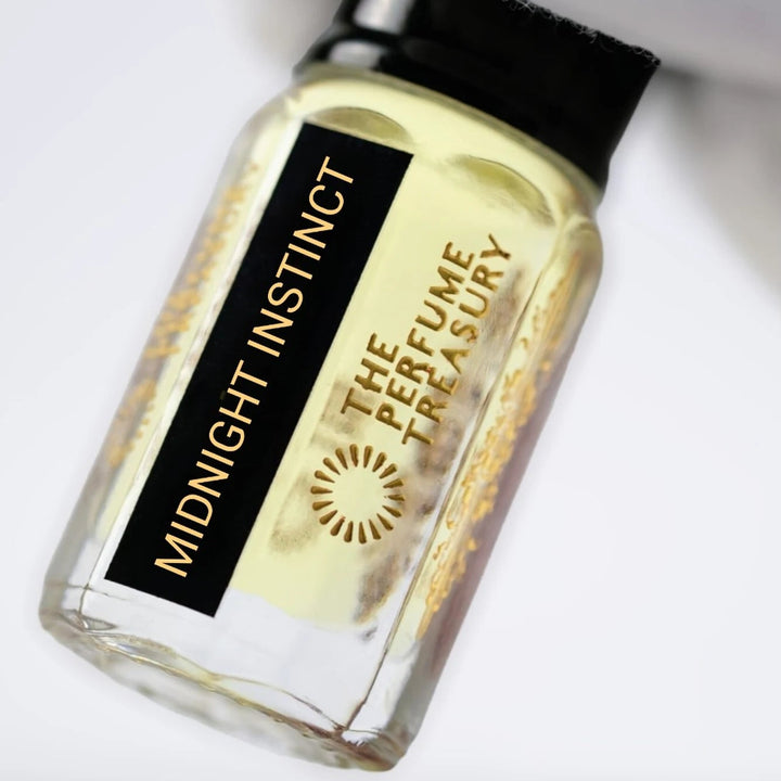 Close-up of Midnight Instinct perfume oil by The Perfume Treasury showing the black and gold label and golden perfume oil.