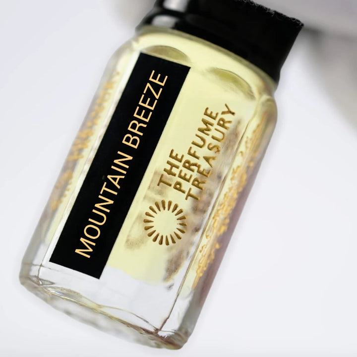 Close-up of Mountain Breeze perfume oil by The Perfume Treasury showing the black and gold label and pale golden perfume oil.