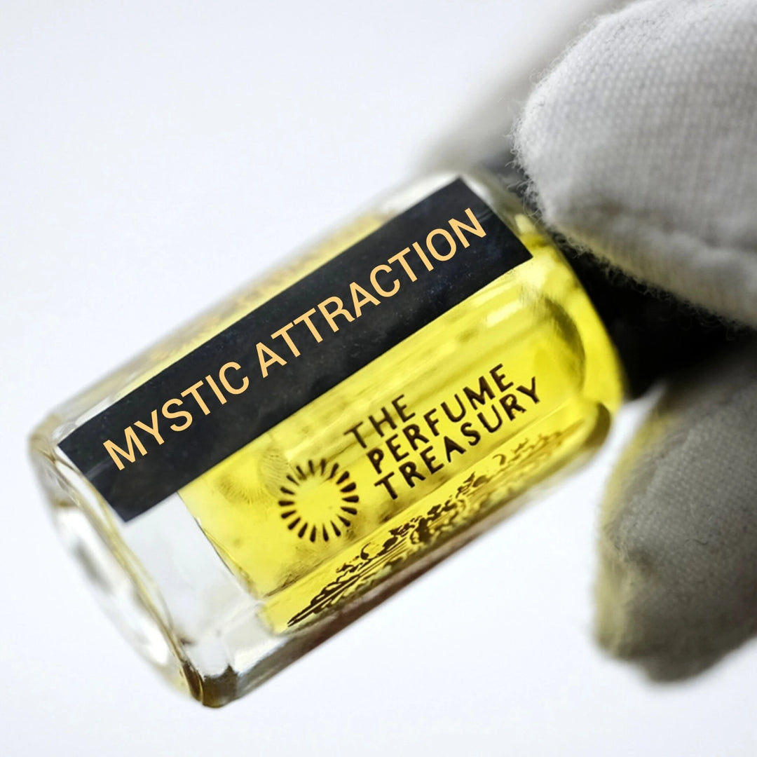 Close-up of Mystic Attraction perfume oil by The Perfume Treasury showing the black and gold label and rich golden perfume oil.