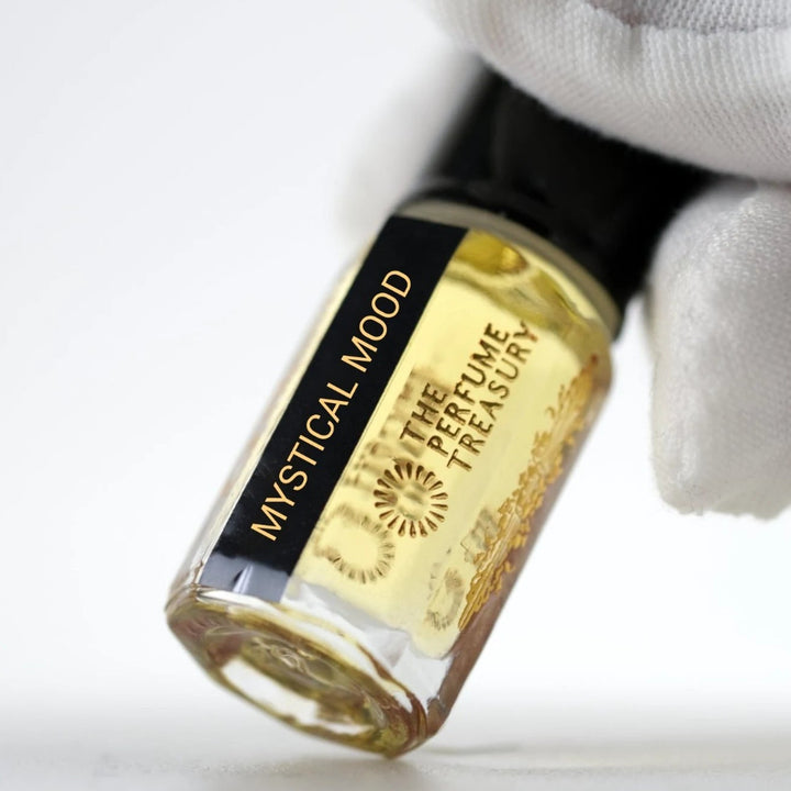 Close-up of Mystical Mood perfume oil by The Perfume Treasury showing the black and gold label and golden perfume oil.