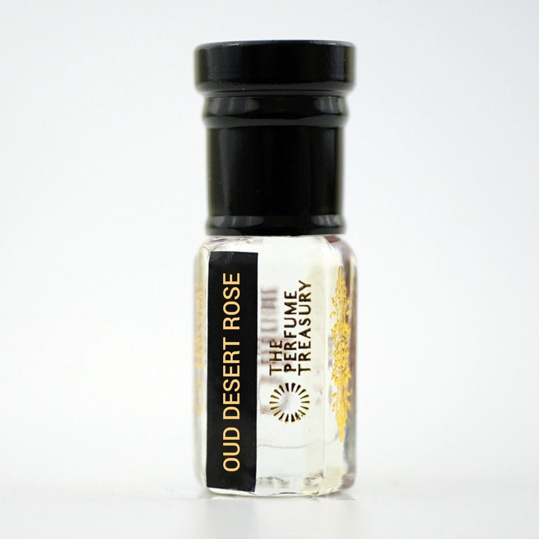 Small clear glass perfume oil bottle with black cap, Oud Desert Rose 3ml attar perfume oil by The Perfume Treasury, clear slightly viscous fragrance oil on white background.
