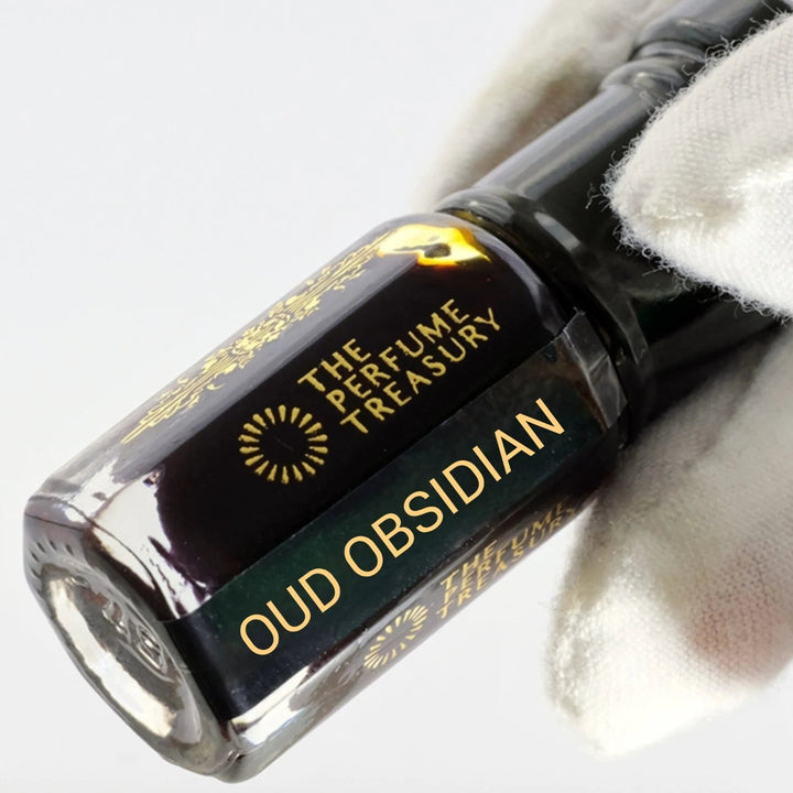 Oud Obsidian perfume oil by The Perfume Treasury shown at an angle, highlighting the dark oud oil and branded glass bottle.