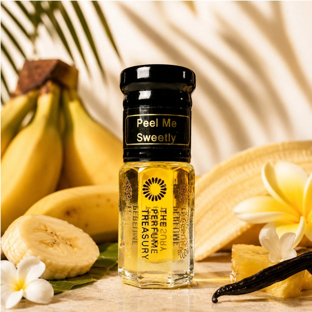 Peel Me Sweetly perfume oil by The Perfume Treasury displayed with ripe bananas, tropical flowers and vanilla in a warm tropical setting.