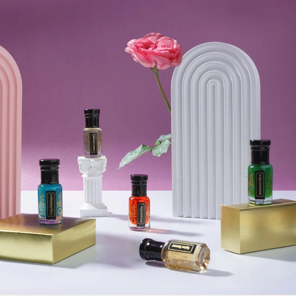 Luxury perfume oil collection by The Perfume Treasury displayed with colourful bottles on gold stands and decorative arches, showcasing a variety of fragrance oils.