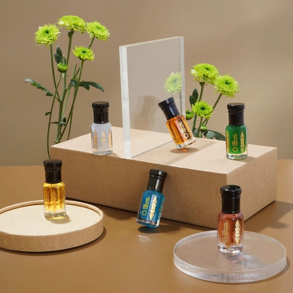 Perfume oil collection by The Perfume Treasury arranged with flowers and neutral props, showcasing multiple fragrance oils in a clean minimal setting.
