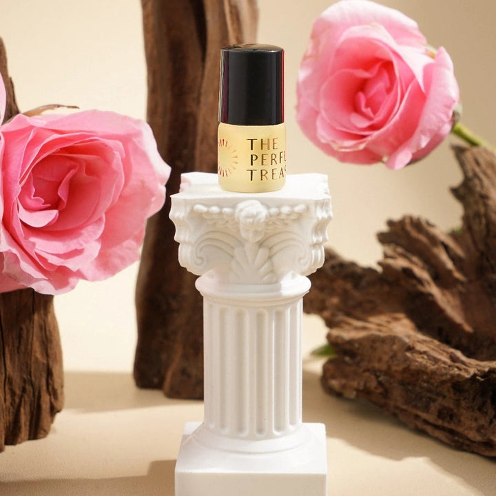 Perfume oil displayed on classical pedestal with roses and wood elements in a luxury setting.