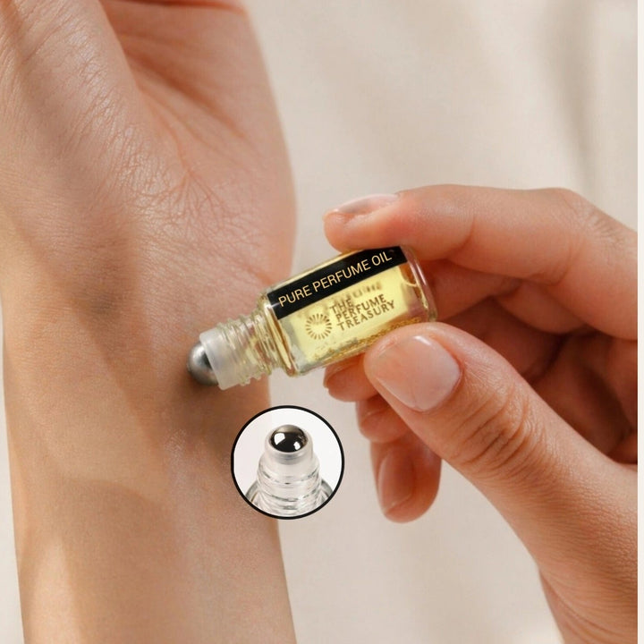 Perfume oil roll-on application showing small clear glass 3ml attar perfume oil by The Perfume Treasury applied to skin, golden fragrance oil with metal roller ball on neutral background.