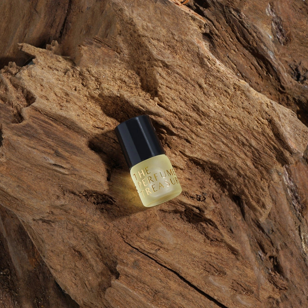 Close-up of perfume oil bottle on natural wood texture, highlighting premium fragrance presentation.