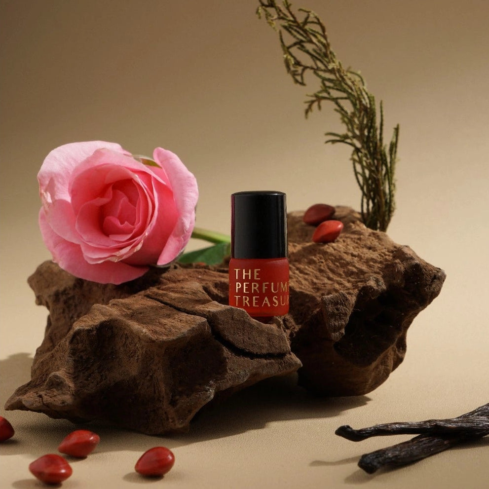 Oud perfume oil displayed on wood with rose and spices, representing deep woody fragrance notes.