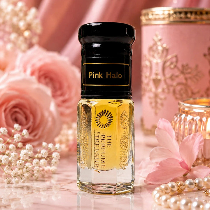 Pink Halo perfume oil by The Perfume Treasury displayed with pink roses, delicate flowers, pearls and warm candlelight in an elegant feminine setting.