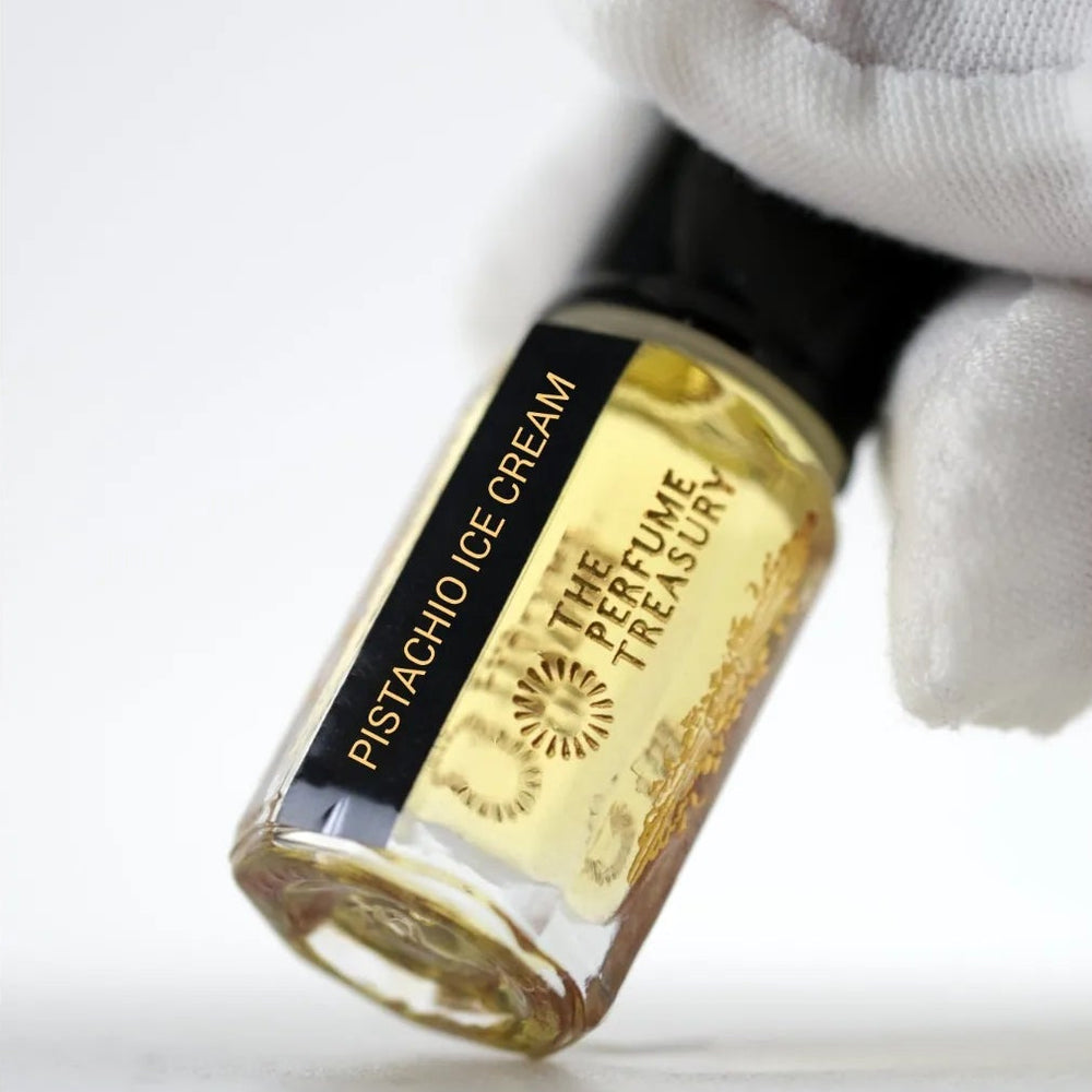Close-up macro of Pistachio Ice Cream 3ml attar perfume oil bottle by The Perfume Treasury, showing smooth creamy golden oil texture and glass shine, luxury fragrance oil.