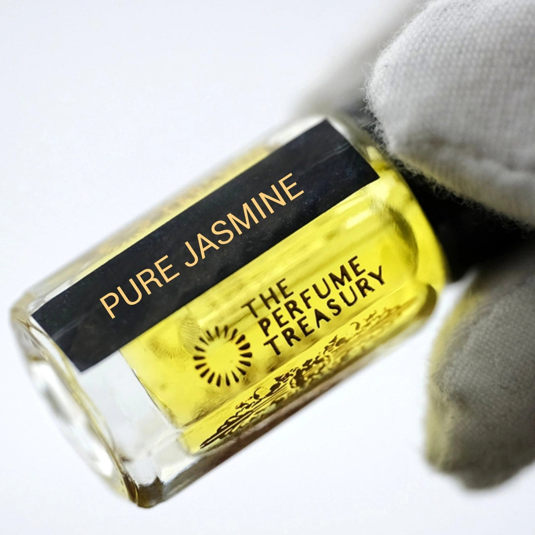 Close-up of Pure Jasmine Attar Perfume Oil by The Perfume Treasury, showing the golden yellow fragrance oil and branded 3ml glass bottle.