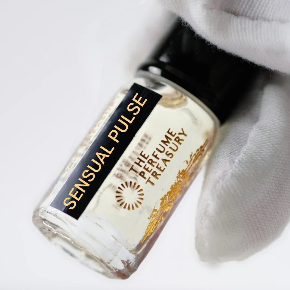 Sensual Pulse perfume oil by The Perfume Treasury held in a white-gloved hand, showcasing the clear glass bottle and black and gold label.