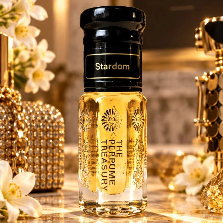 Stardom luxury perfume oil by The Perfume Treasury displayed among white flowers, gold accessories and sparkling accents in an elegant glamorous setting