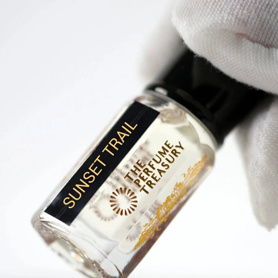 Sunset Trail perfume oil by The Perfume Treasury shown close-up in a clear glass bottle with black and gold label.